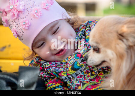 Kleinen und süßen Mädchen mit einem flauschige Hund Stockfoto