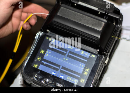 Spleißen von LWL-Kabel mit Optical Fiber Fusion Splicer Instrument professionelles Werkzeug. Modernes und schnelles Internet und Netzwerk Konzept Stockfoto