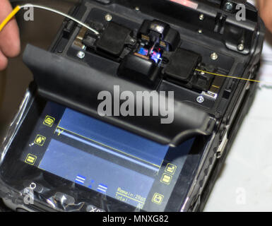 Spleißen von LWL-Kabel mit Optical Fiber Fusion Splicer Instrument professionelles Werkzeug. Modernes und schnelles Internet und Netzwerk Konzept Stockfoto