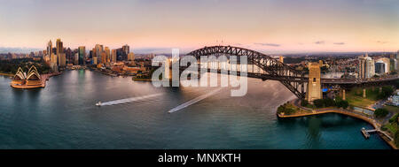 Sehenswürdigkeiten von Sydney City rund um den Hafen auf beiden Seiten der strandgebiete der Sydney Harbour Bridge in weiten Antenne panorama angeschlossen bei Sonnenaufgang. Stockfoto