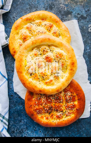 Türkische ramazan Ramadan pidesi - Traditionelle türkische Fladen gebacken in der Regel während des Ramadan Monat. Blauer Stein Hintergrund. Ansicht von oben. Stockfoto