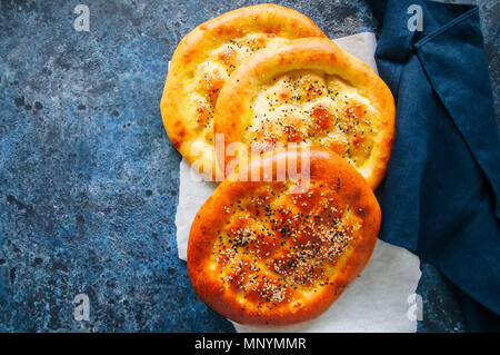 Türkische ramazan Ramadan pidesi - Traditionelle türkische Fladen gebacken in der Regel während des Ramadan Monat. Blauer Stein Hintergrund. Ansicht von oben. Stockfoto