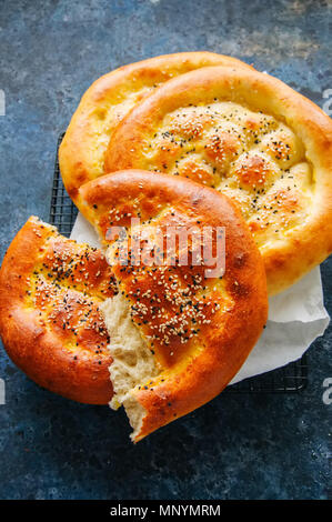 Türkische ramazan Ramadan pidesi - Traditionelle türkische Fladen gebacken in der Regel während des Ramadan Monat. Blauer Stein Hintergrund. Ansicht von oben. Stockfoto