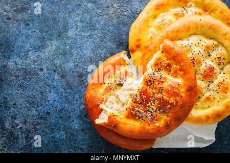 Türkische ramazan Ramadan pidesi - Traditionelle türkische Fladen gebacken in der Regel während des Ramadan Monat. Blauer Stein Hintergrund. Ansicht von oben. Stockfoto