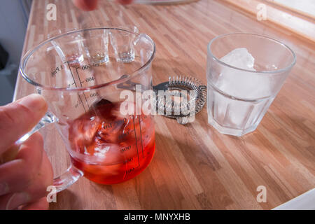 Mischen ein negroni Cocktail auf Holz Küchenarbeitsplatte Stockfoto