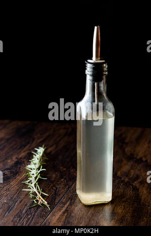 Weißer Essig in der Flasche mit Rosmarin. Ökologische Lebensmittel. Stockfoto