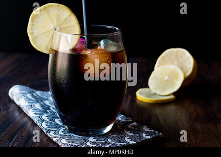 Schwarze Limonade mit Holzkohle, Zitrone und farbenfrohen Bubble ice cubes. Bio Trinken. Stockfoto