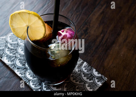 Schwarze Limonade mit Holzkohle, Zitrone und farbenfrohen Bubble ice cubes. Bio Trinken. Stockfoto