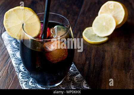 Schwarze Limonade mit Holzkohle, Zitrone und farbenfrohen Bubble ice cubes. Bio Trinken. Stockfoto