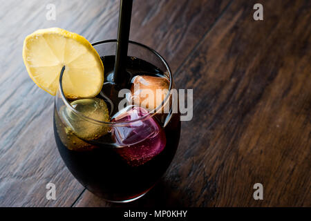 Schwarze Limonade mit Holzkohle, Zitrone und farbenfrohen Bubble ice cubes. Bio Trinken. Stockfoto