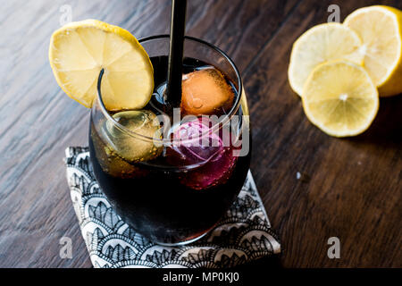 Schwarze Limonade mit Holzkohle, Zitrone und farbenfrohen Bubble ice cubes. Bio Trinken. Stockfoto