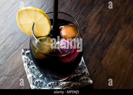 Schwarze Limonade mit Holzkohle, Zitrone und farbenfrohen Bubble ice cubes. Bio Trinken. Stockfoto