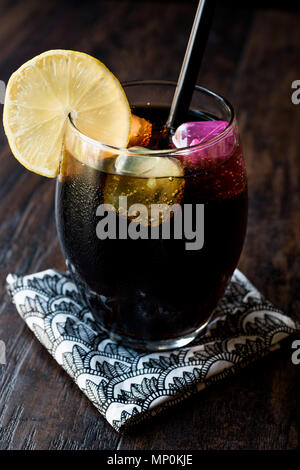 Schwarze Limonade mit Holzkohle, Zitrone und farbenfrohen Bubble ice cubes. Bio Trinken. Stockfoto