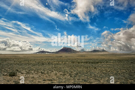 Malerischer Blick auf einem vulkanischen Krater Timanfaya Nationalpark unter einem blauen Himmel mit Wolken. Lanzarote, Kanarische Inseln, Spanien. Stockfoto