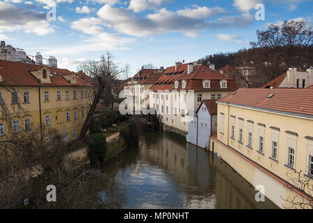 Wassermühle und alte historische Häuser entlang des kleinen Flusses an Kampa, Prag, Tschechische Republik. Blauer morgen Himmel mit einigen Wolken. Stockfoto