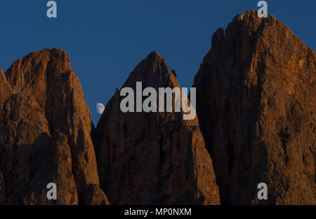 Der Mond und die Geisler Gruppe von Bergen, Teil der Dolomiten im Naturpark Puez-Geisler, Funes Provinz Bozen - Südtirol, Italien. Stockfoto