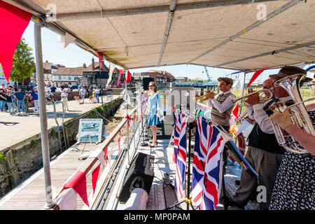 Gruß zu den 40er Jahren beliebte nostalgische Veranstaltung in England. Der Sieg der Kriegszeit Band und Frau Sänger, die auf dem Deck des Bootes mit Union Jack Fahnen. Stockfoto