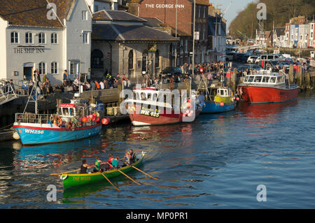 Fischerboote neben Custom House Quay in Dorchester, Dorset vertäut. Eine Crew von Frauen Zeile ein Pilot gig Boot Vergangenheit Urlauber genießen die Sonne. Stockfoto