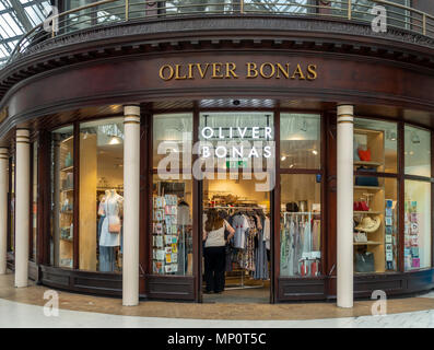 Kunden und die Fassade des Oliver Bonas Steckdose im Hauptbahnhof von Glasgow, Schottland, Großbritannien. Stockfoto