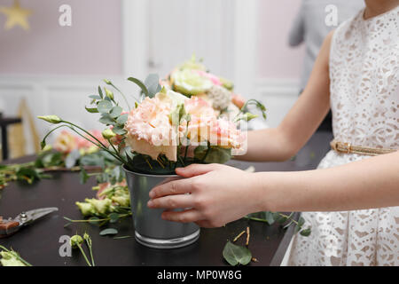 Master Class auf dem Bilden der Blumensträuße für Kinder. Spring Bouquet in Metall dekorativen Blumentopf. Lernen Blumen arrangieren, wunderschöne Blumensträuße mit ihren eigenen Händen. Stockfoto