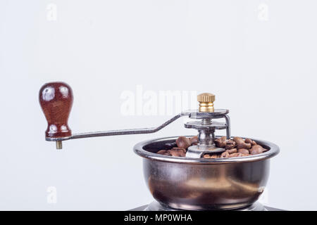 Retro Kaffee Mühle mit gerösteten Kaffeebohnen auf weißem Hintergrund. Close Up, selektive konzentrieren. Essen und Trinken Konzept Stockfoto