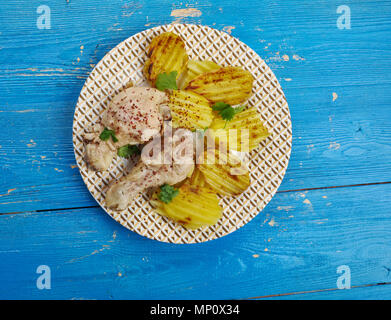 Römertopf erstickt Hähnchenschenkel mit gebackenen Kartoffeln Stockfoto