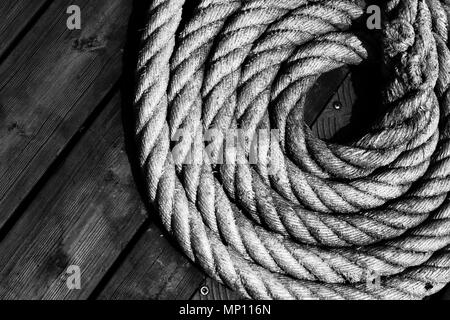 Eine Nahaufnahme von nautischen Spiralkabel Seil auf einem Holzsteg Stockfoto