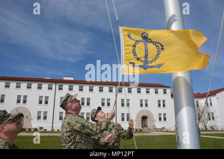 PENSACOLA, Florida (Mar. 7, 2018) - Naval Air Station (NAS) Pensacola kommandierenden Offizier, Kapitän Christopher T. Martin und Boatswains Mate 2. Klasse Cody Cooper die Aufbewahrung Excellence Wimpel zu Ehren der NAS Pensacola von Naval Sea Systems Command für die jährliche Aufrechterhaltung Excellence Award ausgewählt für das Geschäftsjahr (GJ) 2017 anheben. Die Aufbewahrung Excellence Award würdigt, deren Politiken und Programme am besten aktivieren die Matrosen in ihren Marine Karriere Erfolg zu haben, und direkt unterstützt das Konzept der "Brilliant auf der Basis." Stockfoto