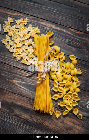 Gemischt mit der Pasta Spaghetti auf Holz- Hintergrund. Ansicht von oben. Stockfoto