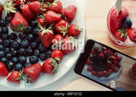 Lecker lecker lecker Hand aus Eis mit Früchten mit Erdbeere Heidelbeere und Eis, flatlay Nahaufnahme Stockfoto
