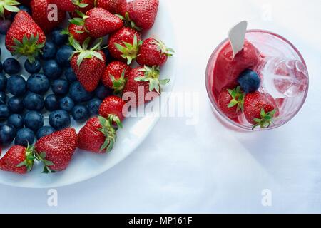 Lecker lecker lecker Hand aus Eis mit Früchten mit Erdbeere Heidelbeere und Eis, flatlay Nahaufnahme Stockfoto