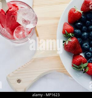 Lecker lecker lecker Hand aus Eis mit Früchten mit Erdbeere Heidelbeere und Eis, flatlay Nahaufnahme Stockfoto
