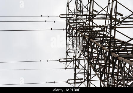 Auf der Suche nach großen Metall Elektrische übertragung Turm mit parallelen Isolatoren und Leitungen gegen bewölkten Himmel. Stockfoto