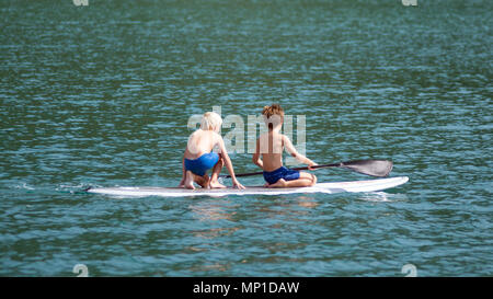 Zwei Jungen auf einer Paddle Board Stockfoto