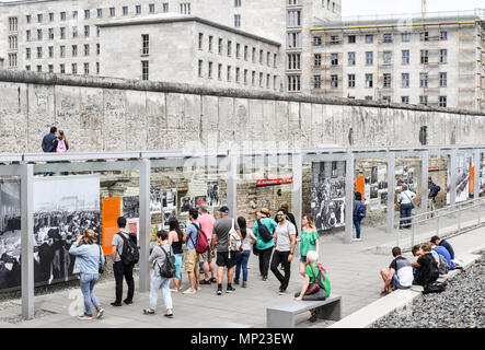 15. Mai 2018, Deutschland, Berlin: Die Besucher werden auf dem Gelände der ständigen Ausstellung "Topographie des Terrors" mit einem Teil der Berliner Mauer. Der Martin-Gropius-Bau (L) und das Abgeordnetenhaus (lit. Haus der Vertreter) der Berlin kann im Hintergrund gesehen werden. Die Ausstellung ist eine der am häufigsten besuchten Gedenkstätten in Berlin. Während des "Dritten Reiches" das Hauptquartier der Gestapo, der Schutzstaffel (SS) und des Reiches wichtigsten Security Office wurden hier entfernt. Foto: Jens Kalaene/dpa-Zentralbild/dpa Stockfoto