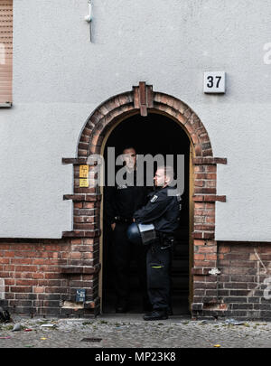 20. Mai 2018, Deutschland, Berlin: Polizisten stehen am Eingang eines besetzten Hauses am Bornsdorfer Straße im Stadtteil Neukölln. Es gehört zu mehreren Objekten, die durch die Allianz besetzt wurden nach ihrer Aussage. Die Polizei beobachtet die Situation. Foto: Paul Zinken/dpa Stockfoto
