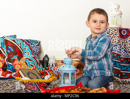 Glückliche junge muslimische Junge spielt mit Ramadan Laterne - bereit für iftar (Frühstück) im Ramadan Stockfoto