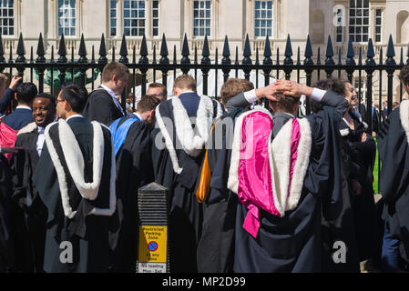 Am Staffelungtag Cambridge Studenten tragen zeremonielle Roben, deren bunte Kappen Identifizieren der Hochschule an der Sie teilgenommen haben, England, UK. Stockfoto