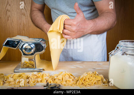 Frische Eier Nudeln zu Hause mit natürlichen Zutaten und einer Grundmaschine Stockfoto