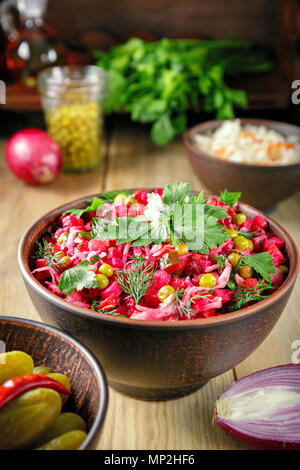 Vinaigrette Salat mit gekochtem Gemüse, Gewürzgurken, Sauerkraut und Konserven Erbsen in einem Ton Schüssel. Traditionelle russische Snack. Vegetarische fo Stockfoto