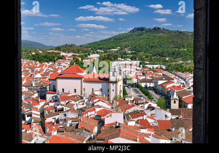 Blick durch eine mittelalterliche Burg Fenster kleine Stadt mit den Bergen im Hintergrund Stockfoto