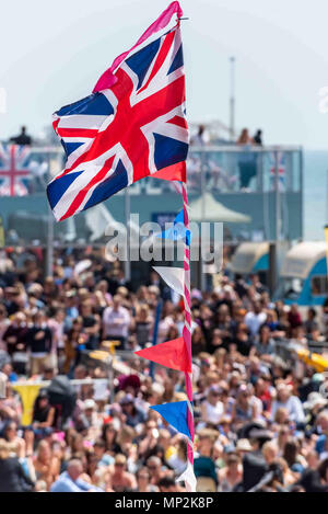 Menschenmassen genießen Sie die königliche Hochzeit auf dem großen Bildschirm in Brighton Beach am Nachmittag. Stockfoto