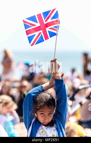 Menschenmassen genießen Sie die königliche Hochzeit auf dem großen Bildschirm in Brighton Beach am Nachmittag. Stockfoto