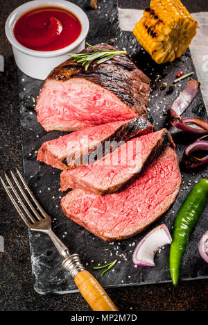 Frisch gegrilltes Rindfleisch, hausgemachter BBQ-Fleisch Medium, auf schwarzen Stein Schneidbrett, mit Gewürzen, dunklen Hintergrund, kopieren Raum Stockfoto