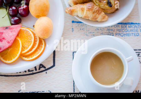 Frühstück mit Kaffee mit Milch, Gebäck und Obst. Guten Morgen. Ansicht von oben. Stockfoto