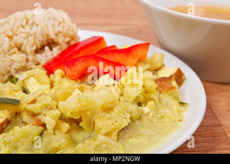 Blumenkohl Mischung mit Curry und Reis auf einem Holztisch Stockfoto