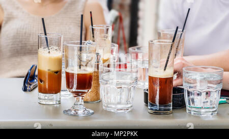 Gläser mit griechischen Frappe kalten Kaffee mit Stroh auf einem Tisch im Freien ein Coffee Shop. Stockfoto
