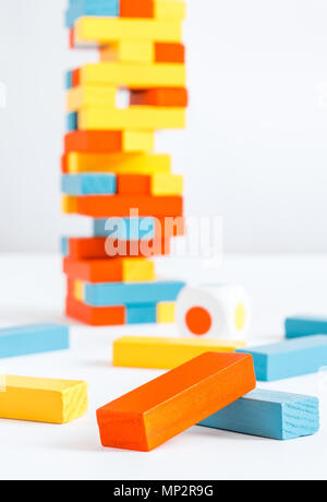 Farbige Blöcke und einen Turm der Jenga Spiel auf einen weißen Hintergrund mit den Würfeln Stockfoto