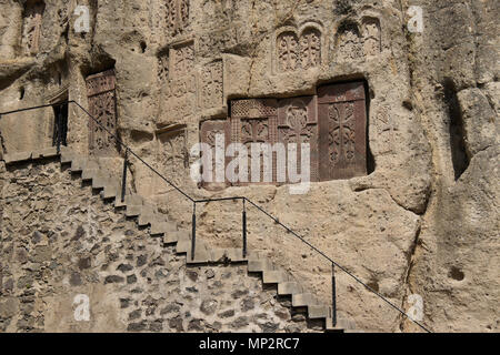 Kunstvoll geschnitzten Stein khatchkars sind in Rock bei Geghard Kloster (Kloster der Speer), Garni, Armenien eingebettet. Stockfoto