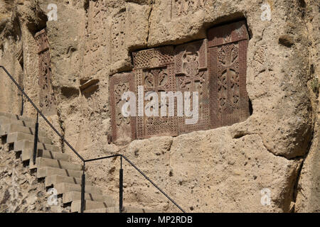 Kunstvoll geschnitzten Stein khatchkars sind in Rock bei Geghard Kloster (Kloster der Speer), Garni, Armenien eingebettet. Stockfoto